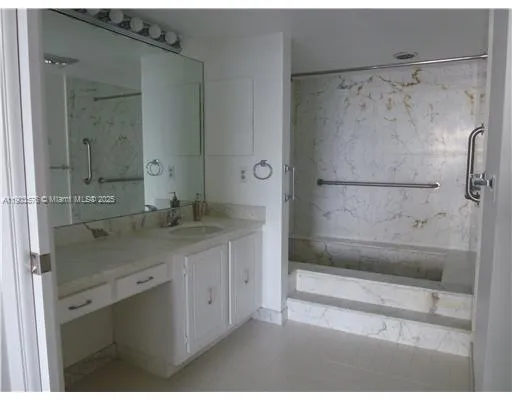 a bathroom with a granite countertop sink mirror and shower