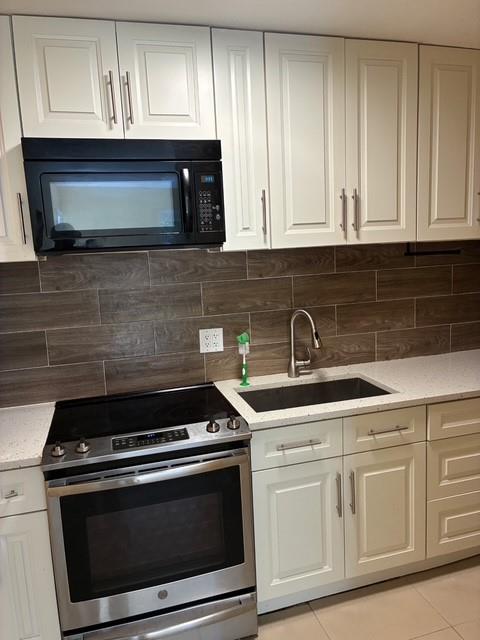 1911 Northeast 28th Street, Unit 4 Lighthouse Point, FL 33064 - Photo 3 of 9 a kitchen with granite countertop white cabinets and appliances