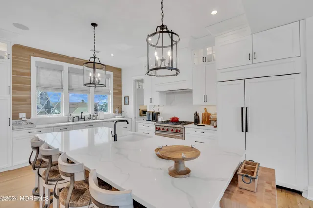 a kitchen with sink refrigerator dining table and chairs