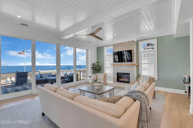 a living room with furniture a fireplace and a floor to ceiling window