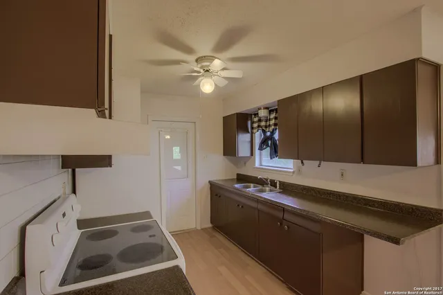 a kitchen with a sink a stove and cabinets