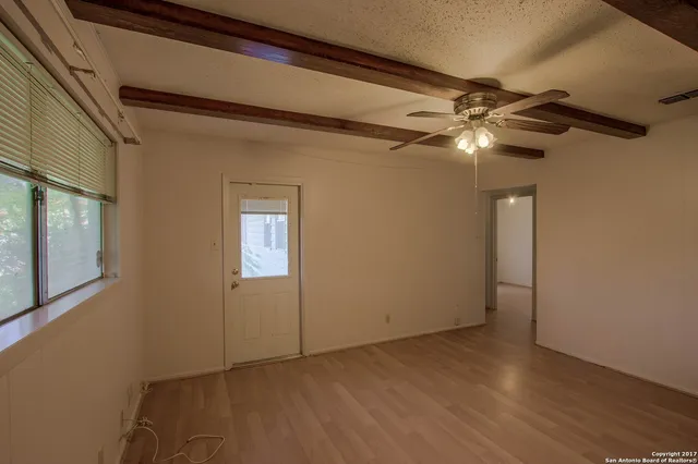a view of empty room with wooden floor