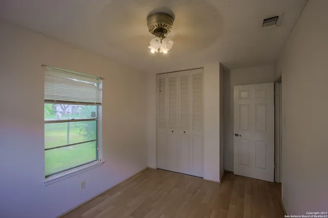 an empty room with a window and a fan