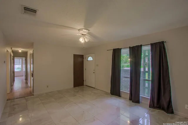 an empty room with fan and entrance