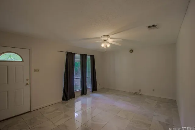 an empty room with closet and a chandelier fan