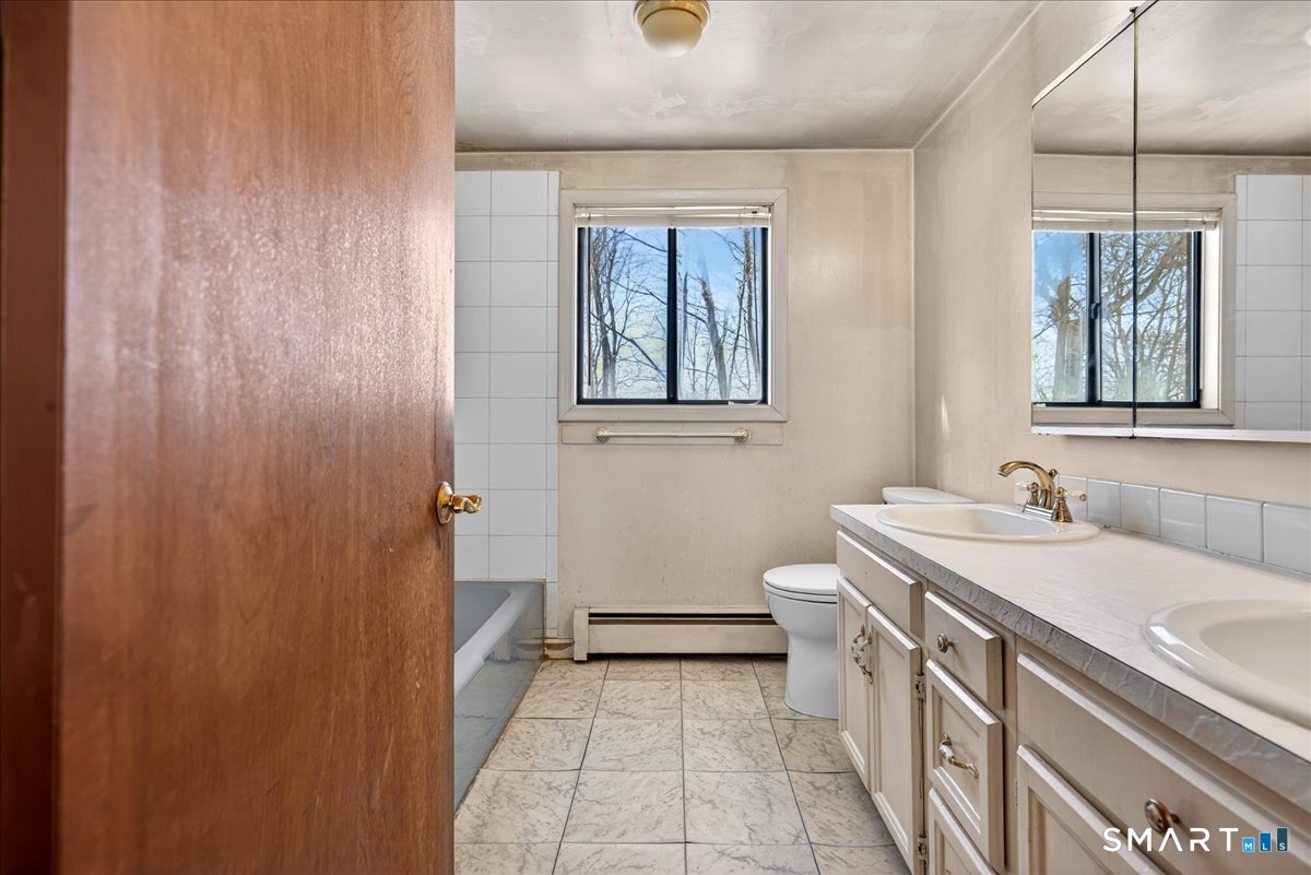 18 Deer Path Lane North Branford, CT 06471 - Photo 19 of 33 a bathroom with a sink a toilet and shower