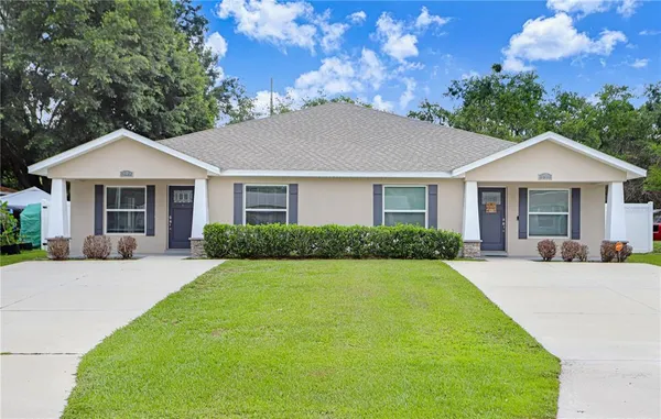 a front view of a house with yard patio and green space