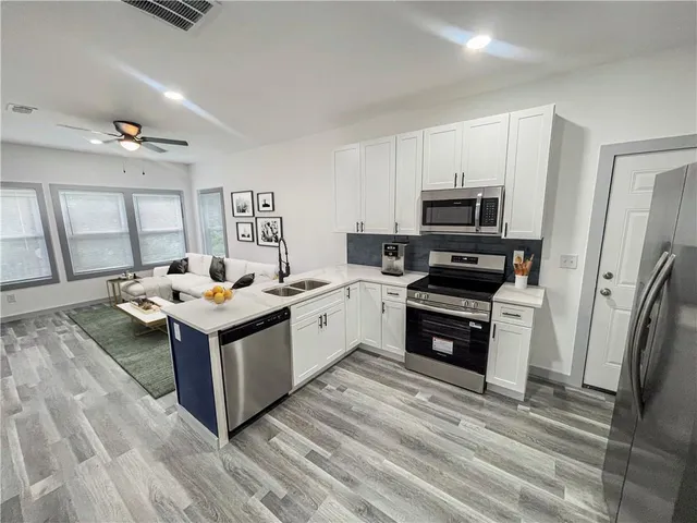 a kitchen that has a sink and a stove top oven