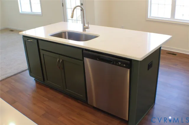 a kitchen with a sink cabinets and wooden floor