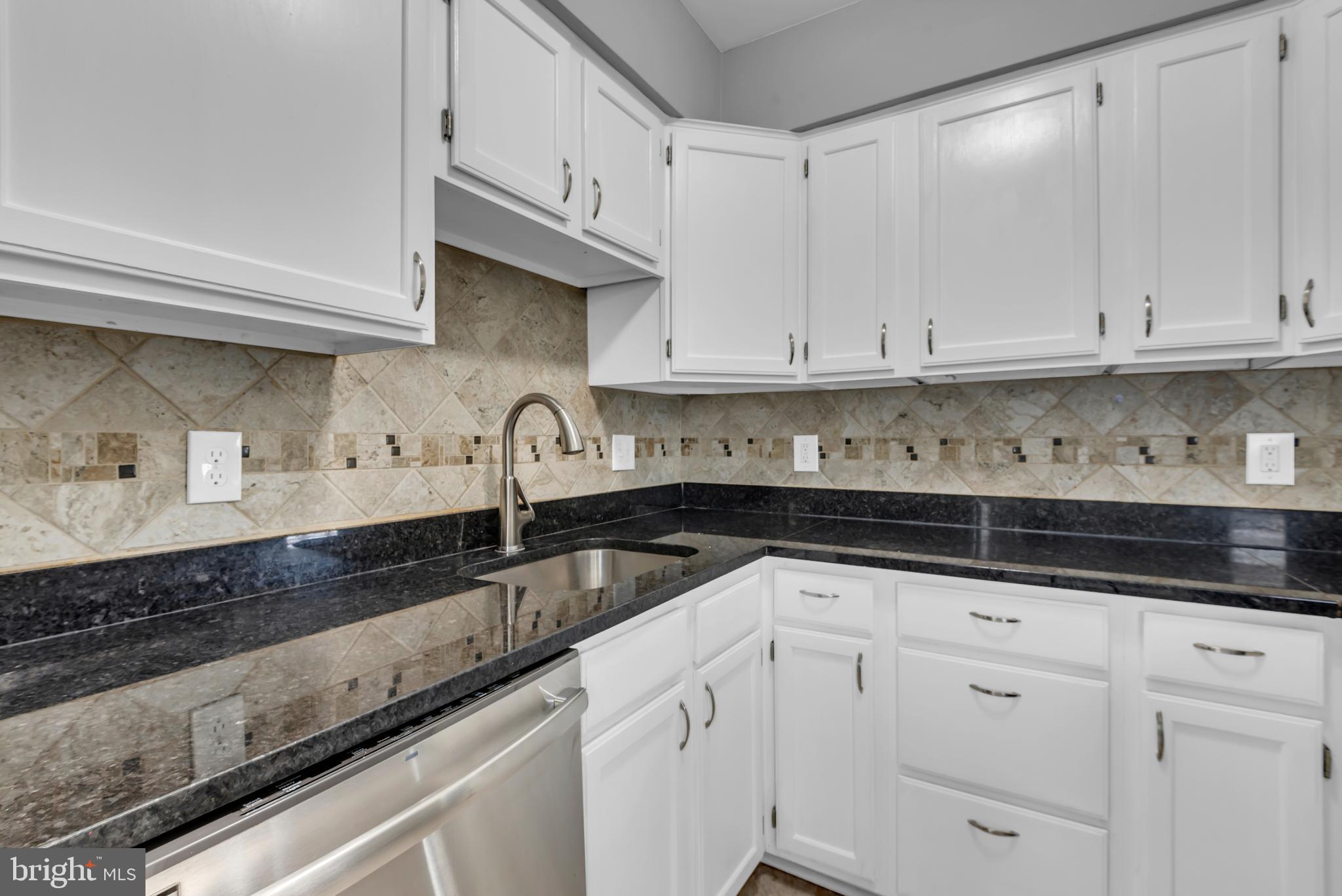 1223 Kendrick Road Baltimore, MD 21237 - Photo 12 of 36 a kitchen with granite countertop white cabinets and white stainless steel appliances