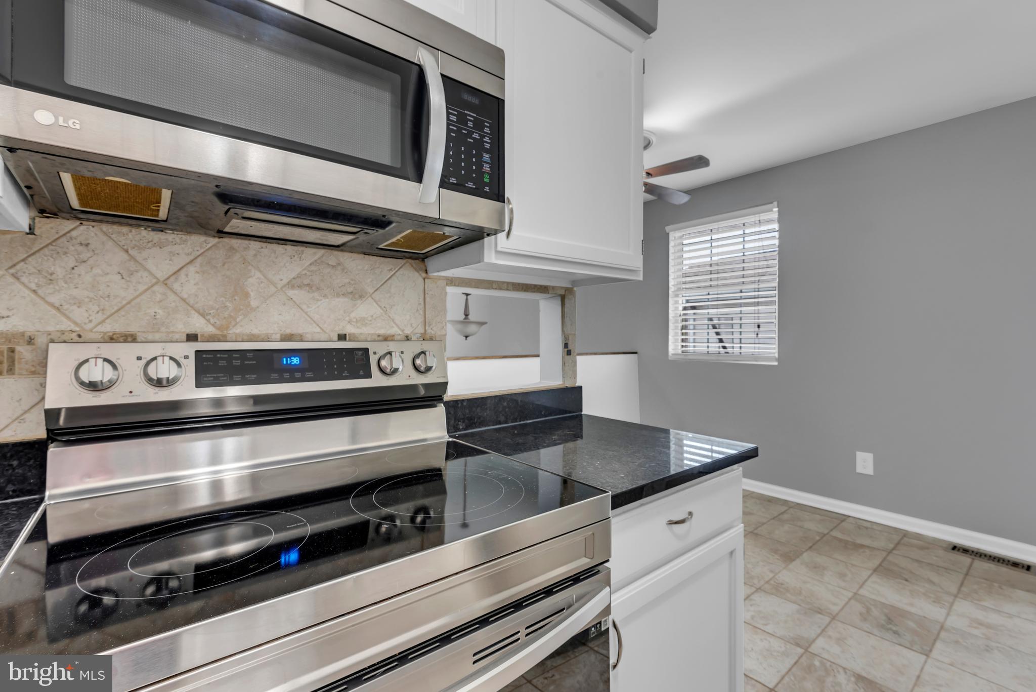 1223 Kendrick Road Baltimore, MD 21237 - Photo 13 of 36 a kitchen with stainless steel appliances granite countertop a stove and a microwave