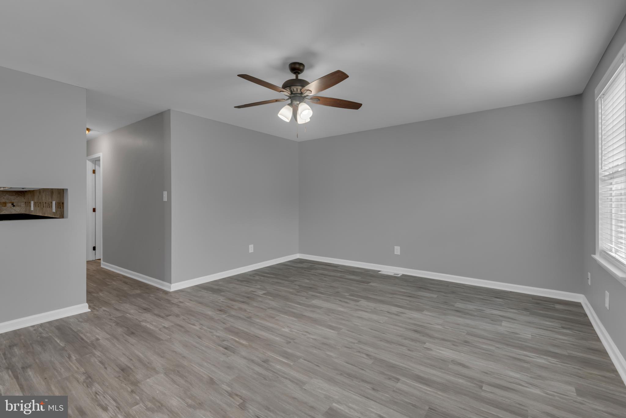 1223 Kendrick Road Baltimore, MD 21237 - Photo 4 of 36 a view of an empty room with wooden floor and a window