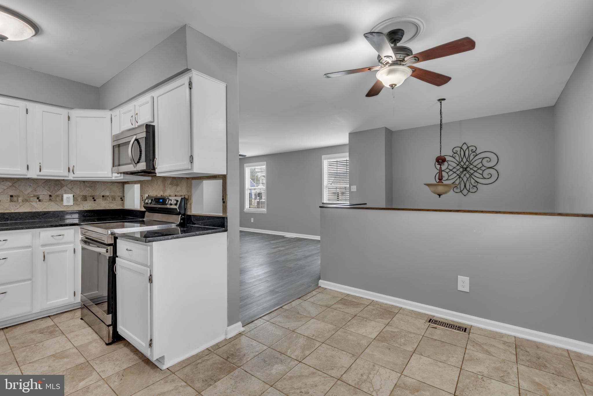 1223 Kendrick Road Baltimore, MD 21237 - Photo 10 of 36 a kitchen with kitchen island white cabinets and white appliances
