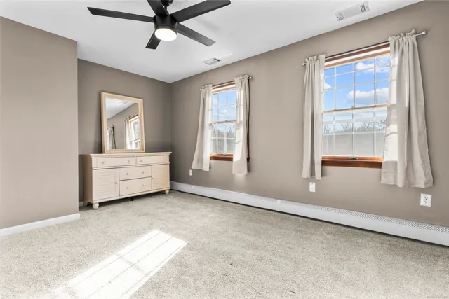 an empty room with windows and fan