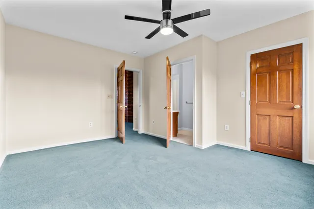 an empty room with closet and a chandelier fan
