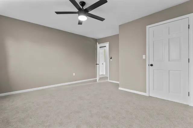 an empty room with windows and fireplace