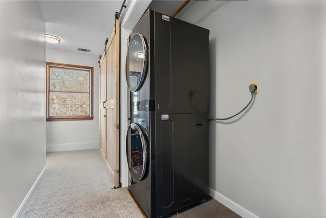 a view of a big room with wooden floor a chandelier and windows