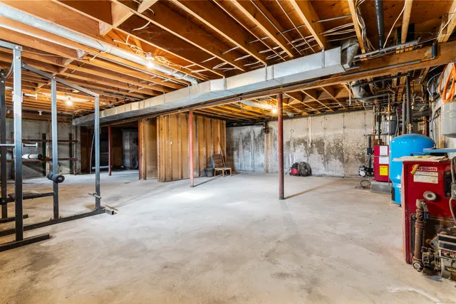 a view of a white house with a large tree and wooden fence