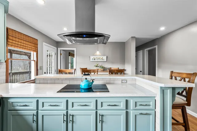 a kitchen with stainless steel appliances a dining table chairs and a refrigerator