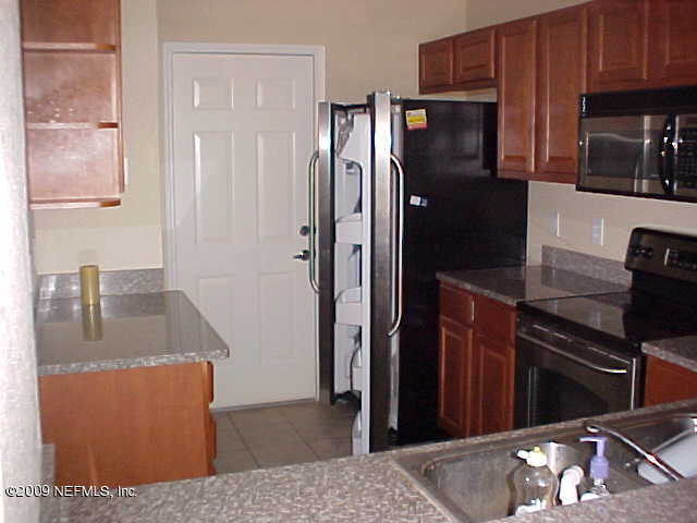 10200 Belle Rive Boulevard, Unit 4702 Jacksonville, FL 32256 - Photo 4 of 10 a kitchen with stainless steel appliances granite countertop a refrigerator and a stove top oven
