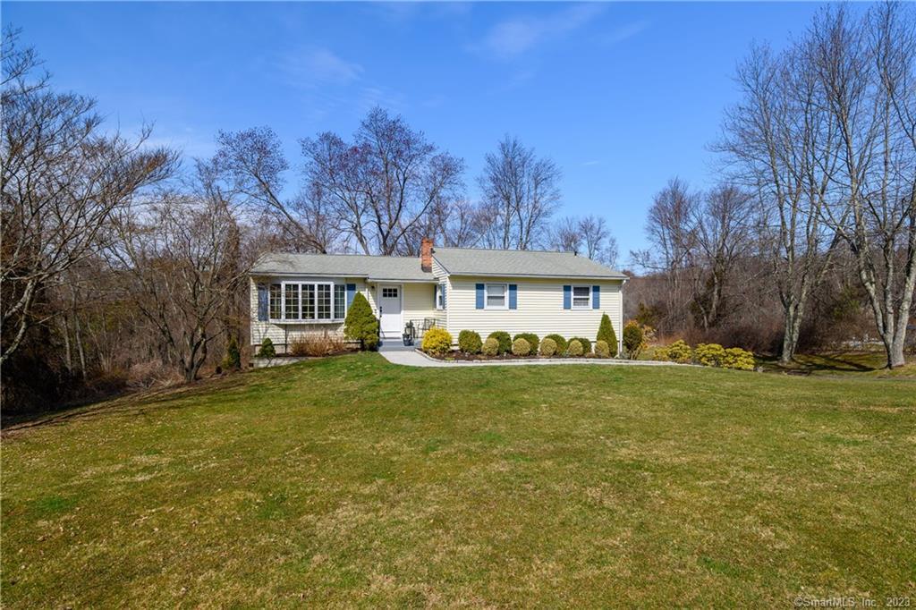 a front view of a house with a yard and trees