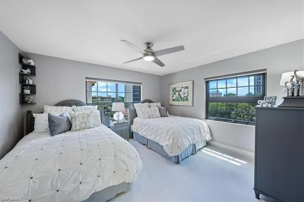 a bedroom with two large bed and a large window