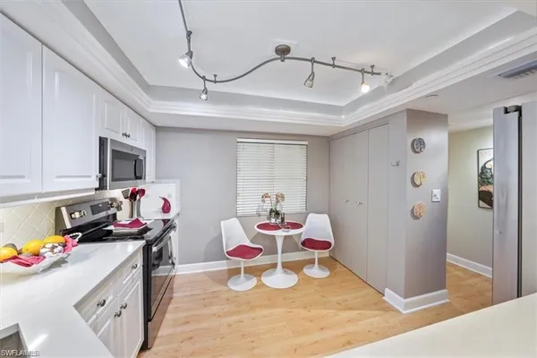 a view of a kitchen with fridge and workspace