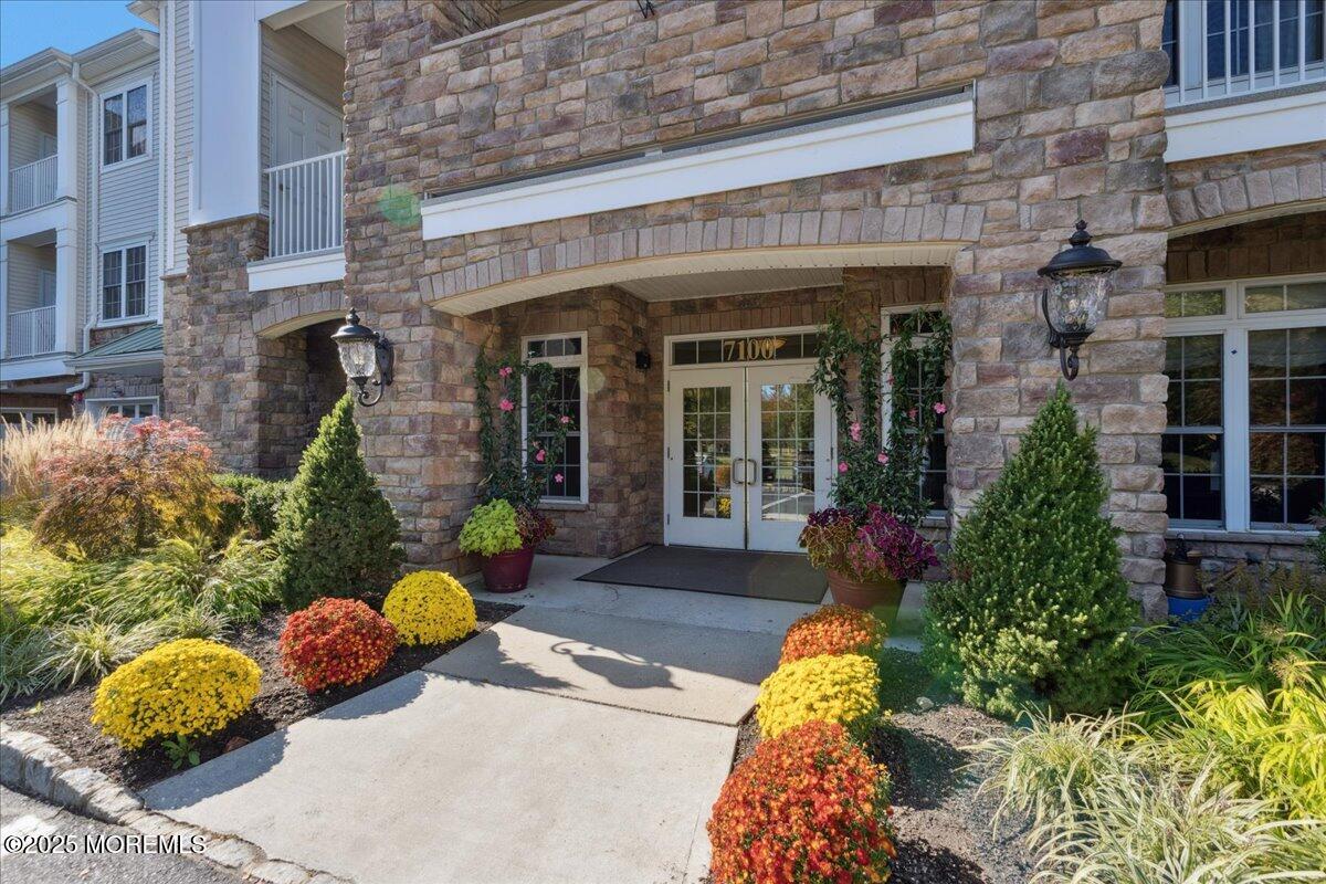 7317 Falston Circle, Unit 7317 Old Bridge, NJ 08857 - Photo 4 of 24 front view of a brick house with a large window and potted plants