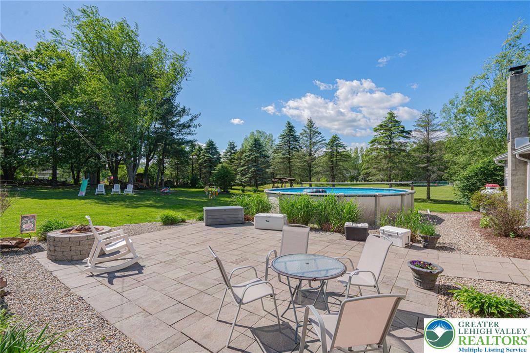 341 Lower Greenhill Road Kunkletown, PA 18058 - Photo 52 of 69 A spacious backyard retreat features an inviting patio area with a fire pit and an above-ground pool, ideal for entertaining.