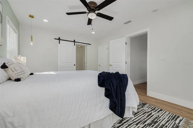 a room with a ceiling fan and wooden floor