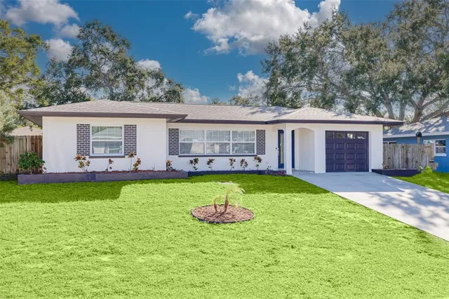 a view of a house with a yard porch and wooden fence
