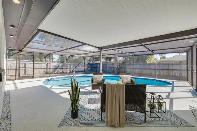 a view of a chairs and table in patio with a barbeque