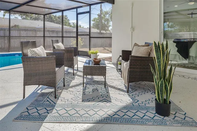a living room with furniture a rug and a floor to ceiling window