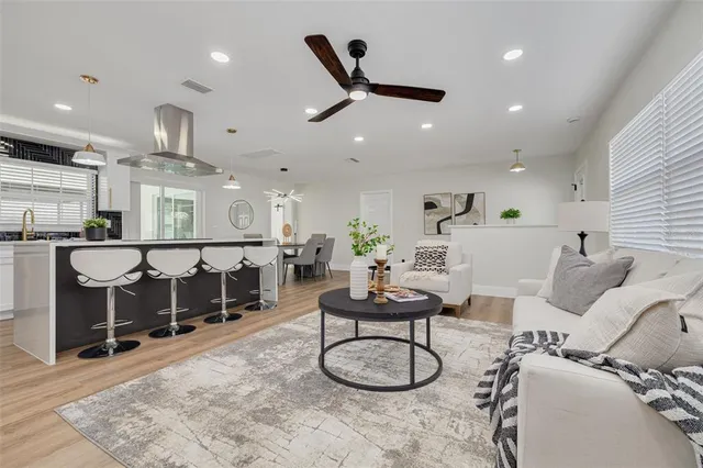a living room with furniture a ceiling fan and a rug