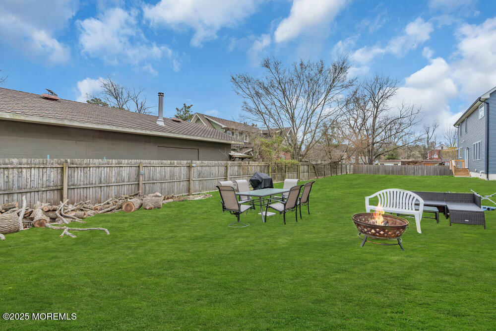 25 Seaton Road Toms River, NJ 08755 - Photo 45 of 52 a view of a backyard with table and chairs and a fire pit