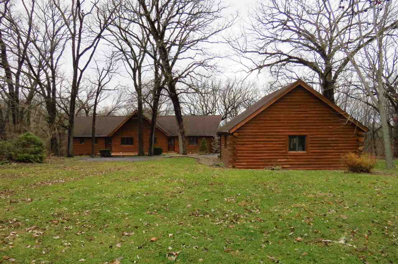 12444 Quail Ridge Close Rockton, IL 61072 - Photo 1 of 24 a backyard of a house with large trees and brick walls