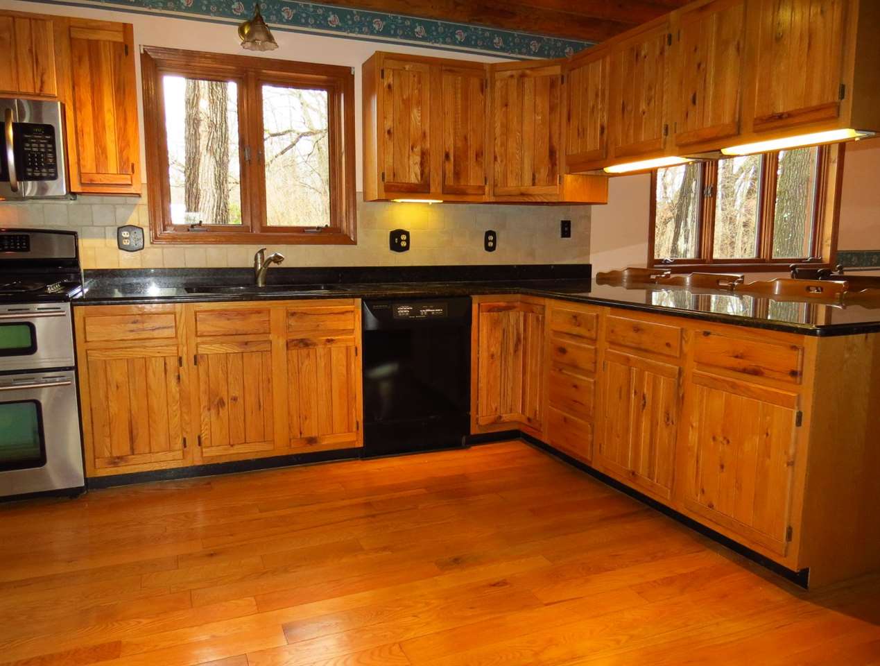 12444 Quail Ridge Close Rockton, IL 61072 - Photo 8 of 24 a kitchen with stainless steel appliances granite countertop a stove a sink and a microwave