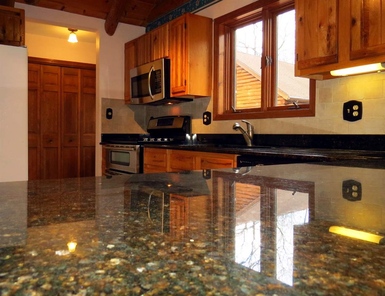 12444 Quail Ridge Close Rockton, IL 61072 - Photo 9 of 24 a kitchen with granite countertop a stove a sink and a microwave