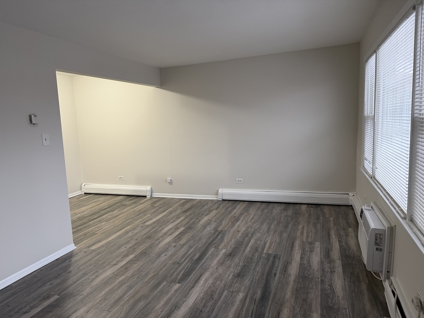 5331 South Kilbourn Avenue, Unit 6 Chicago, IL 60632 - Photo 4 of 11 an empty room with wooden floor and windows