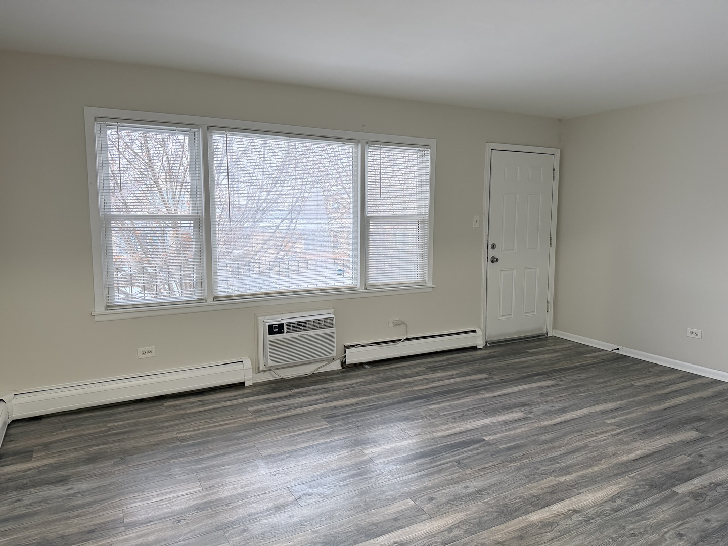 5331 South Kilbourn Avenue, Unit 6 Chicago, IL 60632 - Photo 5 of 11 an empty room with wooden floor and windows