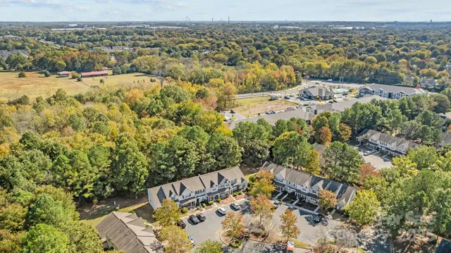a view of a white house with large windows and plants