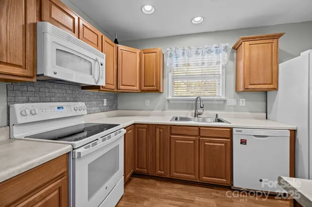 a kitchen with a refrigerator a sink a stove a microwave a counter top space and cabinets