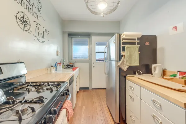 a kitchen with a stove and a wooden floor