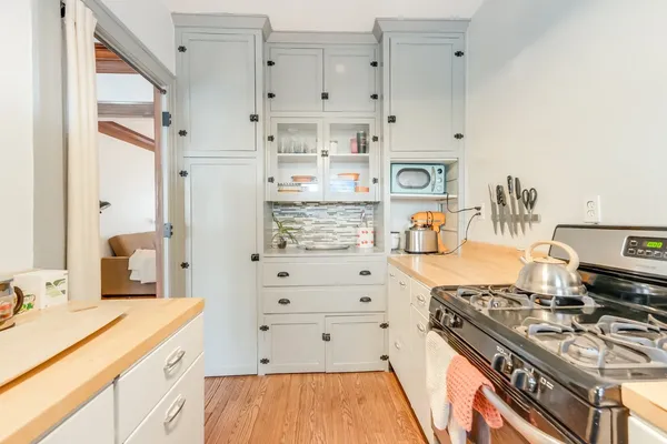 a kitchen with white cabinets and appliances