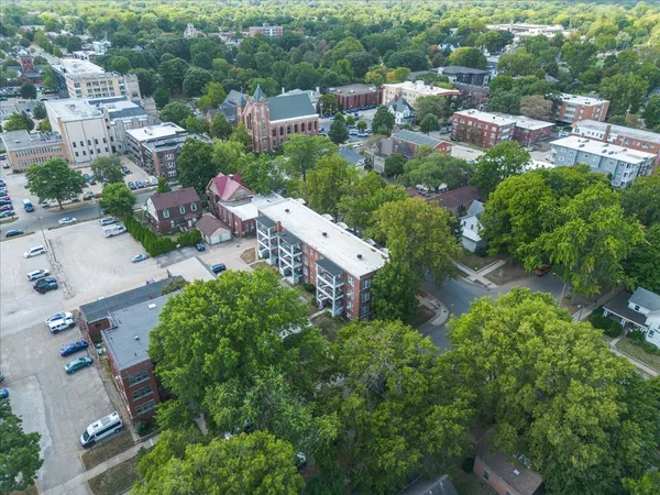 an aerial view of residential houses with outdoor space and trees