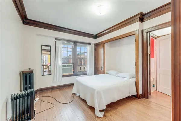 a bedroom with a bed next to a window