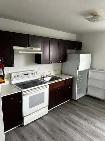 a kitchen with appliances cabinets and a wooden floor