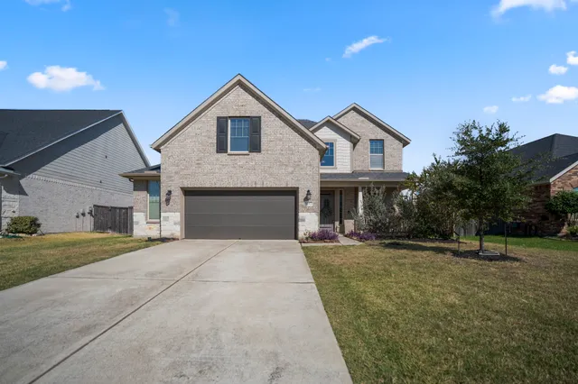a front view of a house with a yard and garage