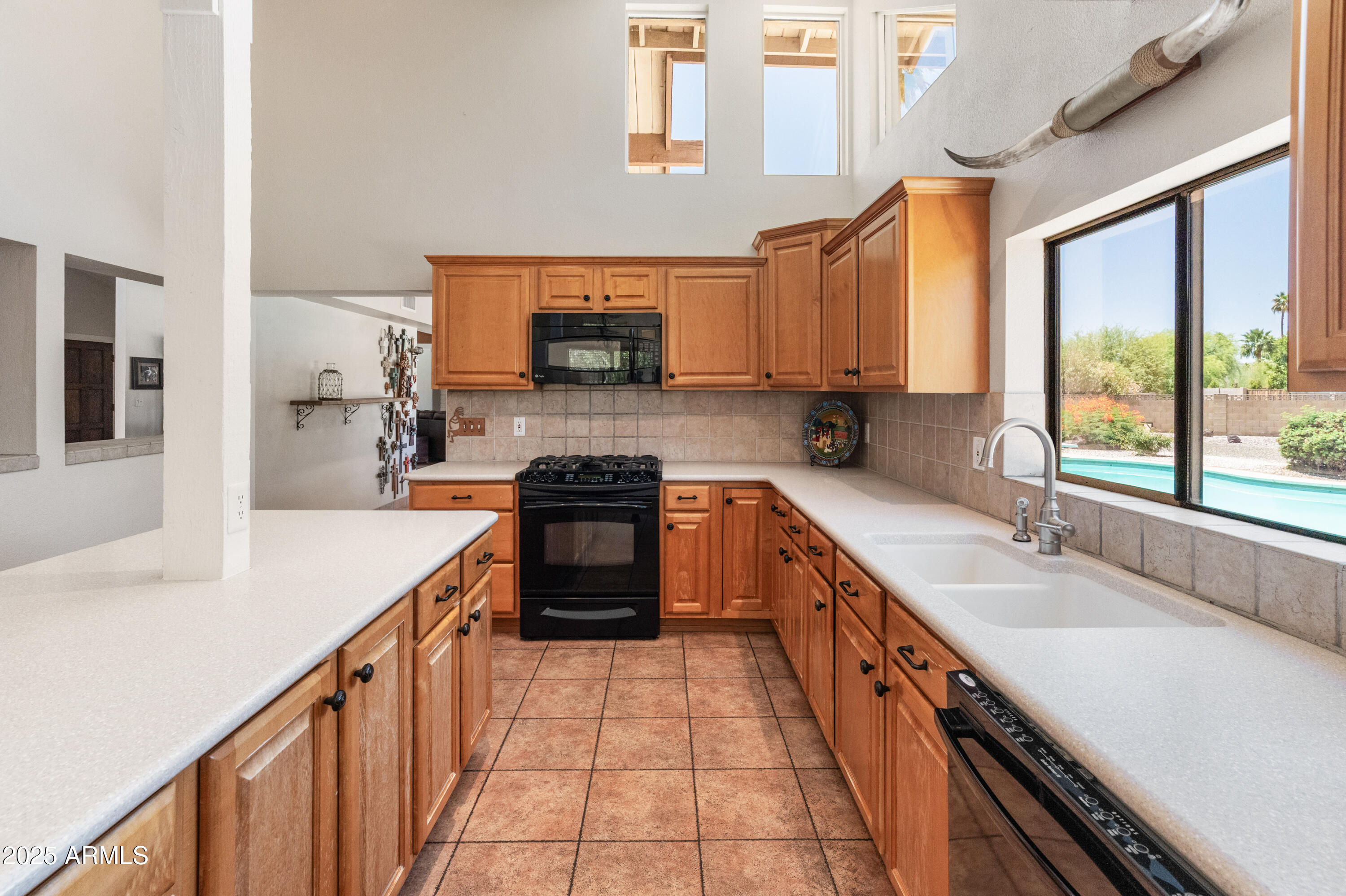 6931 East Pershing Avenue Scottsdale, AZ 85254 - Photo 34 of 59 a kitchen with stainless steel appliances a sink stove top oven and large window