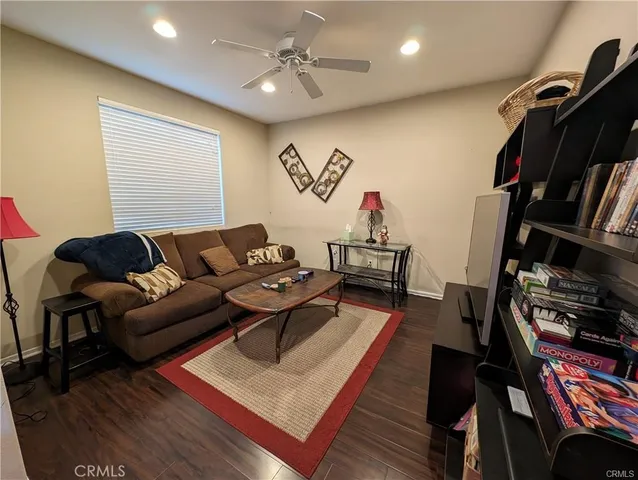 a living room with furniture a rug and a bookshelf
